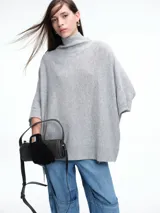 Poncho amplio de cuello alto, confeccionado en hilado con lana y cashmere, con diseño de caída recta y botones laterales.