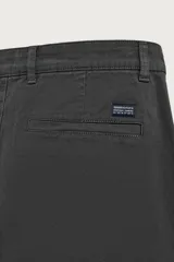 Pantalón chino skinny fit color gris oscuro, confeccionado en mezcla de algodón con elasticidad. Cuenta con bolsillos frontales, bolsillos traseros de vivo y cierre frontal con cremallera y botón.