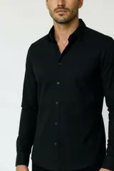 Camisa de poliéster color marrón, de corte holgado, con mangas largas, cuello camisero clásico y cierre frontal de botones.