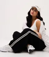 Pantalón pantalona negro de algodón, de corte amplio y cómodo con cintura elástica. Presenta franjas laterales a contratono de diseño deportivo.