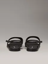 Sandalias planas Calvin Klein de cuero sintético negro, con puntera cuadrada, doble tira ancha y correa ajustable en el tobillo.