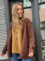 Saco tejido tipo campera color marrón chocolate, con cierre frontal completo, cuello redondo y puños acanalados. Presenta un diseño de corte recto y holgado.