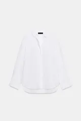 Camisa básica de algodón con cuello solapa, escote en pico y cierre frontal con botones. Presenta mangas largas con puños abotonados y bajo redondeado.