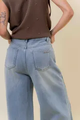 Jean de tiro alto con calce wide leg, confeccionado en denim de lavado celeste claro. Presenta una estructura firme y un interior forrado para mayor abrigo, con bolsillos funcionales.