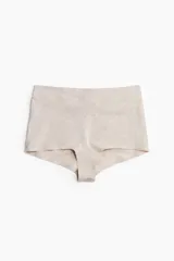 Pack de tres bombachas tipo shortie de algodón, tiro alto, con piernas de corte bajo y refuerzo interior. Los colores son beige melange, blanco y rosado pálido.