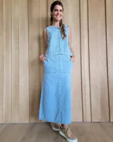 Vestido largo de jean celeste, sin mangas, con corte recto y bolsillos frontales.