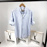 Camisa de algodón a rayas celestes y blancas, con cuello mao y mangas largas.