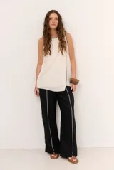 Pantalon de lino negro de corte ancho, con detalles de costuras decorativas claras en el frente.