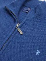Campera de lana azul con cierre frontal y cuello alto.