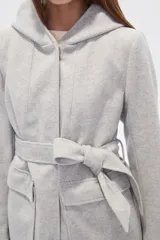 Tapado negro de manga larga con capucha, bolsillos frontales tipo parche y lazo ajustable en la cintura.