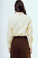 Camisa de manga larga con diseño a rayas verticales en tonos celestes y amarillos sobre fondo blanco, cuello camisero clásico y cierre frontal de botones.