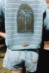 Saco de tejido abierto con aplique central de cuero natural bordado con diseño de palmera.