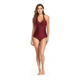Malla entera de color verde oscuro, combinada con un diseño floreado en la parte inferior. Presenta escote halter cruzado y fruncidos en la zona del abdomen.