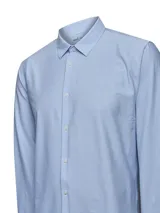 Camisa de manga larga para hombre, color azul claro con finas rayas verticales blancas. Presenta cuello camisero y puños abotonados.