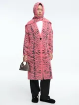 Saco largo de tejido de punto con textura peluda, estampado de cebra en tonos rosa y negro, con cierre frontal de un botón y capucha integrada.