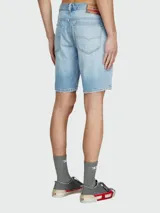 Short de jean celeste con efecto lavado, corte recto, largo a la rodilla y terminación desflecada. Tiene cinco bolsillos y cierre con cremallera y botón.