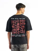 Remera blanca de corte oversize con cuello redondo y manga corta. Presenta un pequeño estampado frontal de un envase de bebida con texto en japonés y una flor.