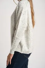 Sweater de punto con diseño jaspeado, cuello redondo y corte oversize. Presenta costuras visibles en los hombros y puños acanalados.