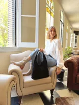 Bolso tipo tote bag negro de cuero, con costuras a la vista y manijas cortas.