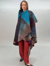 Capa de lana merino afieltrada, con diseño de espiral en tonos azul, marrón, gris y borgoña.