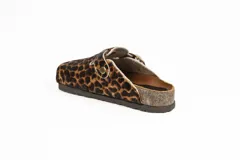 Zueco de cuero con estampa tipo animal print de vaca, con tira de ajuste marrón y hebilla metálica. Plantilla anatómica y suela de corcho y goma.