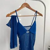 Top azul eléctrico con escote halter y abertura en el centro del busto. Incluye mangas largas de tul a juego.