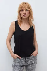 Musculosa blanca básica de corte recto, con escote redondo a la base y tirantes anchos.