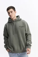 Canguro con capucha color verde oliva, de corte regular, con estampado gráfico multicolor en la espalda que incluye texto y formas abstractas.