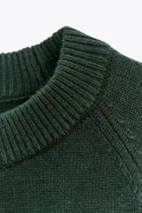 Jersey de punto liso color bordó, con cuello redondo y mangas anchas de largo tres cuartos. Presenta acabados en rib en cuello, puños y ruedo.