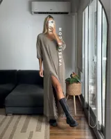 Vestido largo negro de tela de Cey, con escote en V, mangas largas abullonadas, tajo lateral con detalle de encaje y ruedo con encaje.