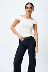 Jean negro de calce flare con cinturón incorporado en la misma tela y silueta ajustada en cadera que se ensancha hacia el ruedo.