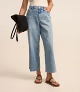 Pantalón de jean celeste, modelo recto cropped, tiro alto, con trabillas en la cintura, cierre con botón y cremallera, bolsillos delanteros y traseros, y terminación deshilachada.