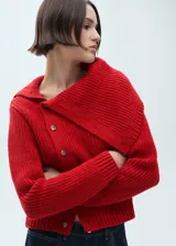 Jersey de punto grueso color rojo, con cuello chimenea amplio y cierre frontal de botones. Presenta diseño recto y manga larga.