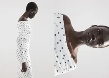 Vestido midi entallado de color blanco con estampado de lunares negros, escote palabra de honor con solapa drapeada y manga larga.