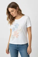 Remera de algodón color blanco, de corte holgado, con cuello redondo y mangas cortas. Presenta un estampado floral en tonos pasteles en la parte frontal.