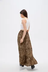 Falda larga de poliéster con estampado animal print de leopardo, diseño de corte amplio con volados en el ruedo y cierre frontal con botones.