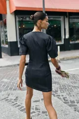 Vestido corto de denim oscuro con cuello redondo, mangas cortas abullonadas y costuras decorativas en contraste. Presenta un corte entallado y cierre posterior con cremallera oculta.