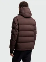 Campera puffer de esquí Moncler Grenoble modelo Isorno, color marrón oscuro, con capucha ajustable, cierre frontal, bolsillos laterales y puños con aberturas para pulgares.