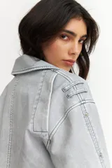 Campera corta estilo motociclista color gris claro, con efecto desgastado y cierre cruzado.