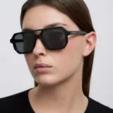 Lentes de sol con montura estilo aviador contemporáneo, de color negro con doble puente estructural y lentes polarizadas oscuras.