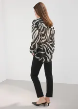 Camisa de lyocell de corte recto con estampado de cebra, cuello camisero, manga larga con puños abotonados y cierre frontal de botones.