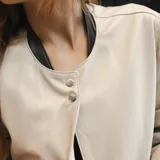 Chaqueta larga color beige de cuero ovino italiano con forro interno y cierre con botones a presión.