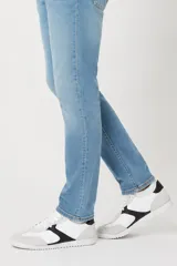 Zapatilla de estilo urbano con diseño bicolor en blanco y negro, con detalles en gamuza gris en la puntera y el talón. Presenta cordones blancos y suela de goma plana.