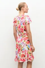 Vestido corto cruzado con estampado floral, escote en V, mangas cortas con vuelo, lazo ajustable en la cintura y detalle de volados en el borde inferior.