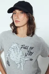 Remera blanca de manga corta con estampado gráfico de un gato marrón y un ratón, y la frase "Full of Joy" en amarillo.