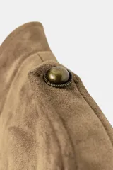 Cazadora de efecto ante con cuello subido, manga larga con trabillas en los hombros, detalle de falsos botones dorados tipo alamares en la parte frontal y cierre con cremallera.