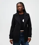 Saco femenino de corte estructurado, color negro, con solapas amplias, cierre frontal de doble botonadura y mangas largas con trabillas en los puños.