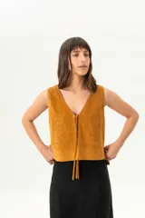 Chaleco de gamuza color mostaza, con escote en V y cierre frontal con lazos.