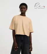 Remera cropped de manga corta, cuello redondo y calce oversized, confeccionada en tejido de algodón tipo media malla.