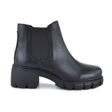 Botín Chelsea de cuero sintético negro con elásticos laterales, caña baja y suela track con taco ancho.